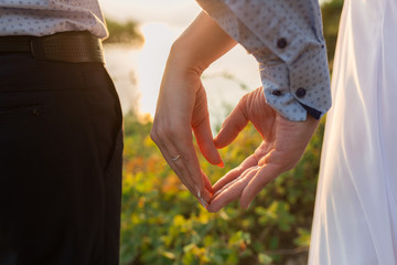 close up of a couple love holding or making hand for heart shape as romantic wedding concept