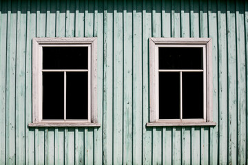 Vintage rustic wooden window frame. Black empty copy space inside. Old peeling paint cottage house wall.