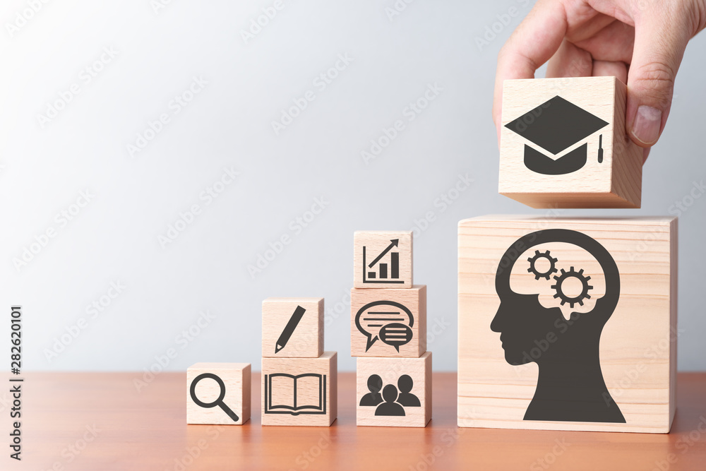 Aufkleber education and stock of knowledge. building wood blocks on table.