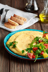 Omelet with cheese coupled with rucola, spinach, tomato, paprika and seasoning. Continental breakfast or English breakfast.