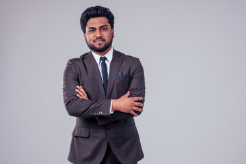 Obraz na płótnie Canvas Arabic handsome businessman with cool hairstyle posing in a suit in the studio on a white background