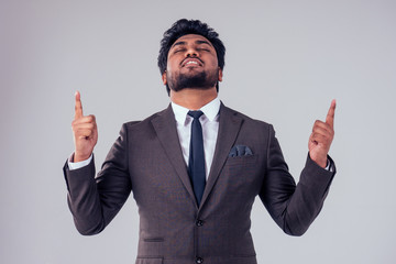 Arabic handsome businessman with cool hairstyle posing in a suit in the studio on a white background