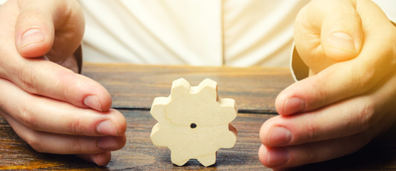 Businessman and wooden gear. Establishing business processes and communications. Development of...