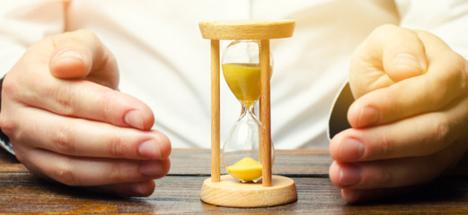 Man protects the hourglass. Concept of saving time and money. Time management. Planning work....