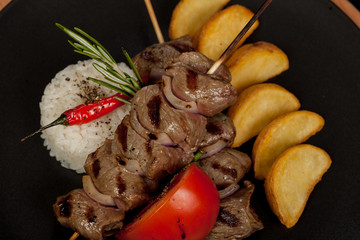 juicy, fried, tender steak with vegetables and sauces on a special stand