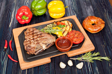 juicy, fried, tender steak with vegetables and sauces on a special stand