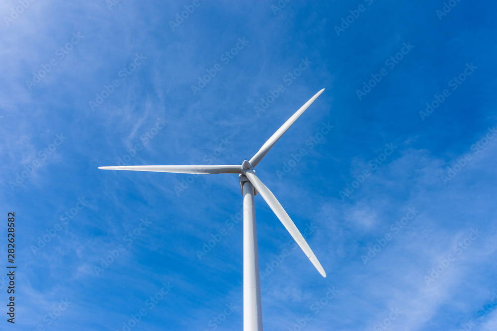 Wall mural wind turbine over mountains and blue sky