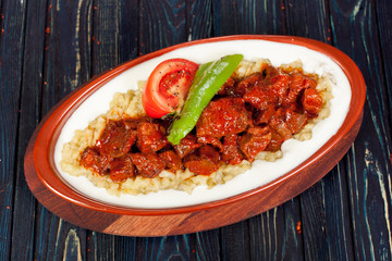 juicy, fried, tender steak with vegetables and sauces on a special stand