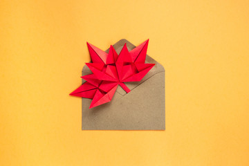 Autumn leaf in an envelope on an orange background. Origami from red paper. The concept of gifts, discounts, sales, incoming messages. Autumn bright background