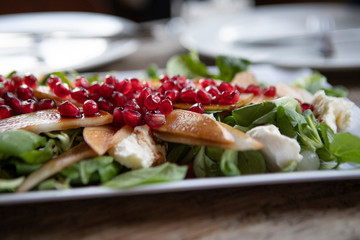 plate with green salat, pomegranate and fungi