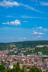 Germany, Television tower building of stuttgart city on green forested hill next to houses in basin...