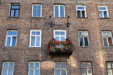 Facade of an old slum house with decorated balcony and damaged brick walls in a poor and criminal district. Location: Brzeska street, Praga district of Warsaw city, Poland - 282630769
