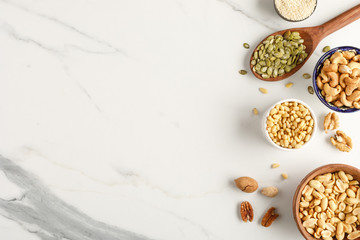 Frame made of different types of nuts in bowls