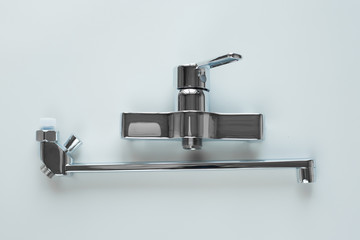 New steel bathroom faucet with one handles on a gray background. The concept of home repair is the choice and replacement of plumbing.