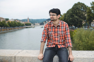 smiling man sitting on bridge