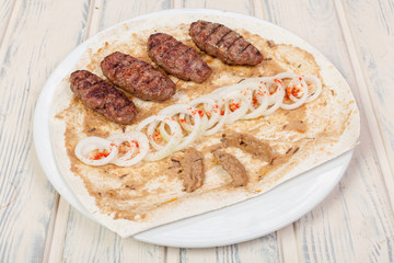 juicy, fried, tender steak with vegetables and sauces on a special stand