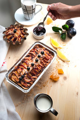Freshly baked plum pie with delicious plum jam and drinks on a wooden board with drapery