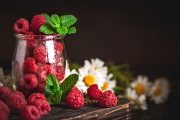 Raspberries in a Cup on a dark background. Summer and healthy food concept. Background with copy space. Selective focus. Vertical.