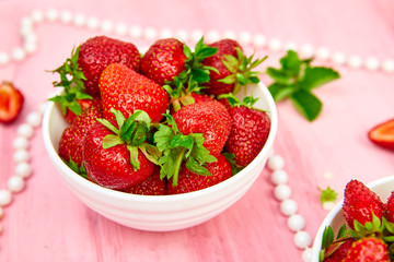 Ripe red strawberries on pink table, Strawberries in white bowls. Fresh strawberries. Beautiful strawberries. Diet food. Healthy, vegan. Top view. Flat lay.