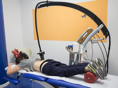 Diamagnetic Pump for Pain Therapy: Woman lying on aBed Undergoing Therapy