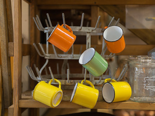 Yellow and Orange colors Empty Cups Hanging on a Little Iron Hanger