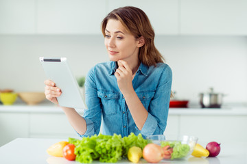 Portrait thoughtful beautiful concentrated lady wife house browse information use laptop rest modern technology tasty dish weightloss ponder touch chin long wavy hairdo casual denim shirt apartment
