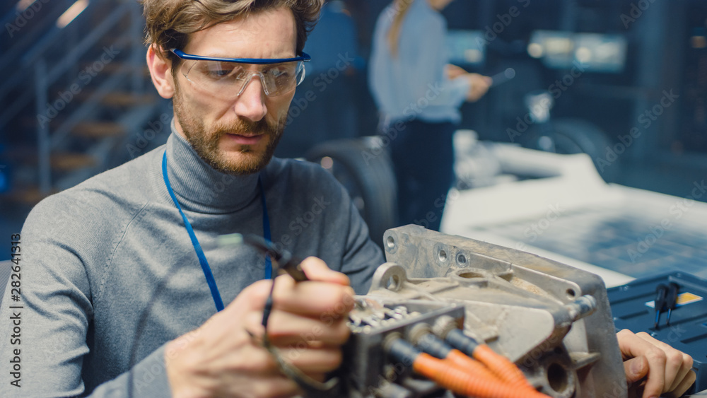 Leinwandbilder professional automotive engineer in glasses with a computer and inspection tools is testing an used 