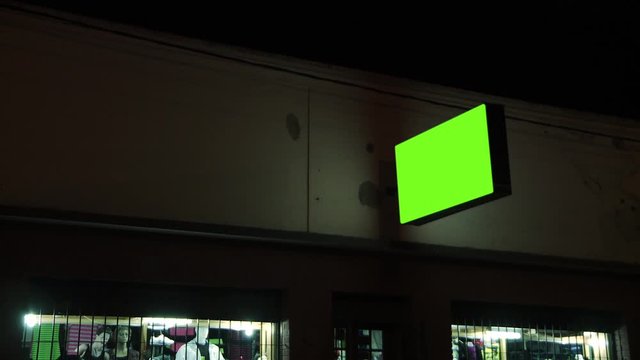 Empty Green Screen Street Shop Board on the Street at Night. You can replace green screen with the footage or picture you want with &ldquo;Keying&rdquo; effect in AE (check out tutorials on Internet).