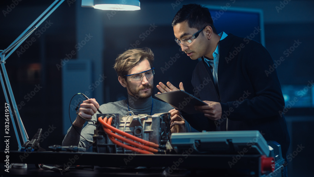 Aufkleber Two Professional Automotive Engineers with a Tablet Computer and Inspection Tools are Having a Conversation While Testing an Electric Engine in a High Tech Laboratory with a Concept Car Chassis.