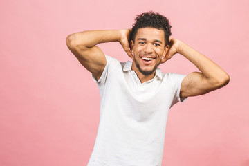Fototapeta na wymiar A young happy smiling funny African American male isolated against pink background.