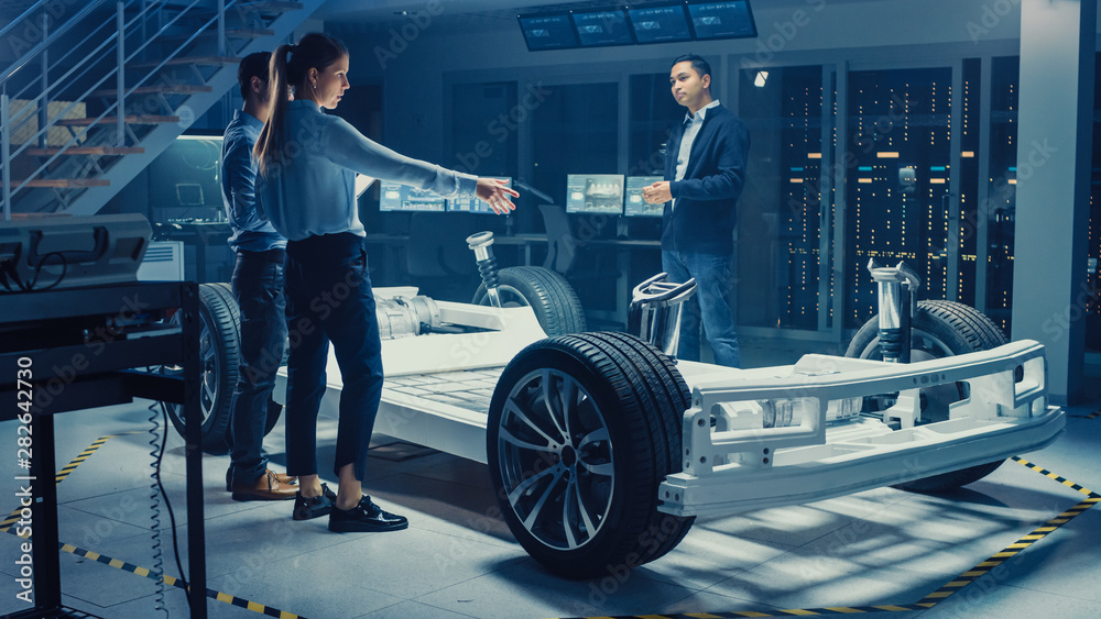 Aufkleber automotive design engineers talking while working on electric car chassis prototype. in innovation l