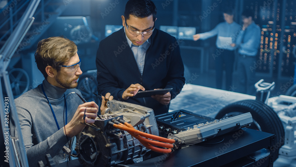 Leinwandbilder two professional automotive engineers with a tablet computer and inspection tools are having a conve
