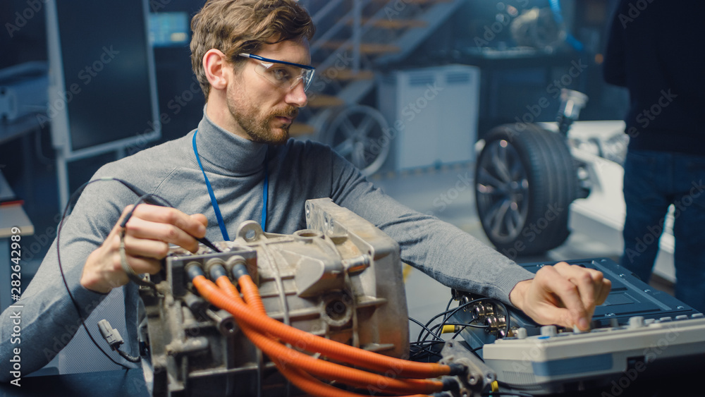 Fototapete professional automotive engineer in glasses with a computer and inspection tools is testing an used 
