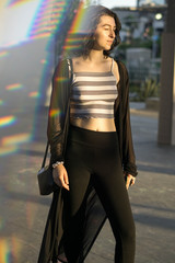 young woman facing the sun with eyes closed prism reflection