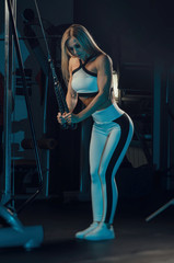 Fototapeta na wymiar the girl athlete in sportswear is training at the gym