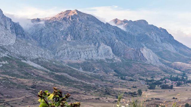 Time lapse of a sunset in the mountains of Leon with clouds passing between the peaks.