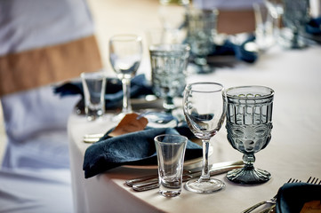 Classic table setting. Blue napkin and glasses. Banquet