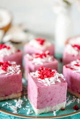 Raw vegan cakes volcanoes made from fermented cashew butter with raspberry jam, decorated with coconut flakes and freeze-dried raspberries. Close-up, selective focus