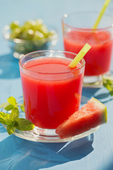 Cold fresh watermelon juice on a wooden blue table.