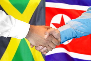 Business handshake on the background of two flags. Men handshake on the background of the Jamaica and North Korea flag. Support concept