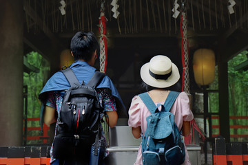 Backpack teen boy and girl respect belief by beautiful mind together within shrine at Arashiyama.