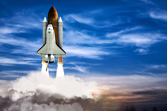 A shuttle spaceship taking off on background of blue night cloudy sky.