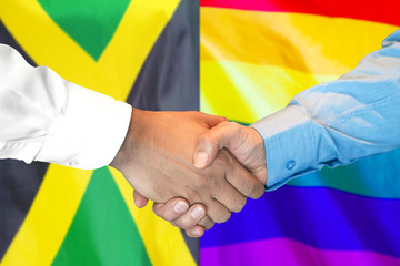 Business handshake on the background of two flags. Men handshake on the background of the Jamaica and LGBT gay flag. Support concept