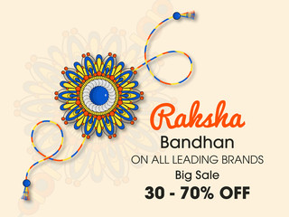 Beautiful rakhi with gems on shiny red and beige background for the festival of Raksha Bandhan celebrations.