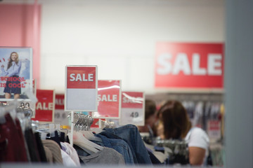 Season sale, black friday and shopping concept. Red label  discount price in shop. Clothes hangers on background.