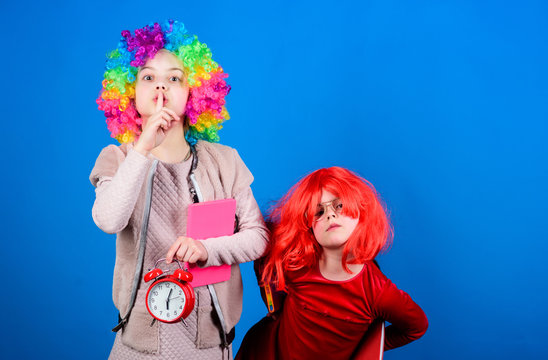 Circus school education. Time to have fun. Kids colorful curly wig clown style hold alarm clock. I am not joking about discipline. School alarm. Girl worry about time. Discipline and time concept