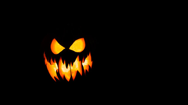 Halloween pumpkin with scary face on black background.