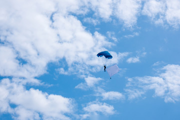 photo of a blue sky with a skydiver on a cloudy summer day