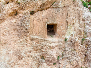 Aerial view of bas-reliefs carved in the rock that adorn the entrance frame of a house carved into the rock on the steep side of a mountain. House near the ruins of the Dogubayazit castle. Turkey