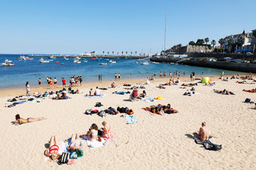 Cascais, Lisbon, Portugal - June 28, 2019: Tourists enjoy Ribeira Beach or Fisherman's Beach, in the center of Cascais, in Lisbon District, in Portugal.